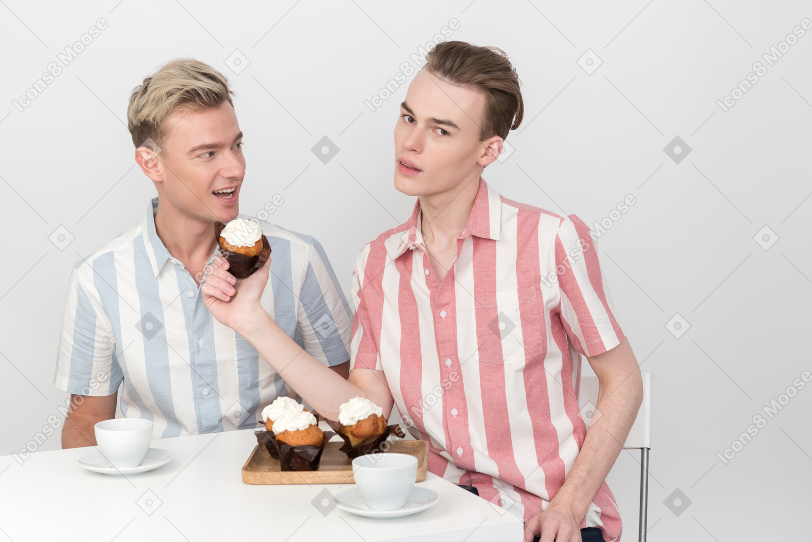 彼のパートナーにカップケーキを食べることを提案している男