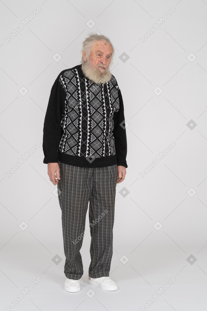 Sad-looking elderly man standing with arms at side