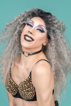Portrait of a drag queen in studded bra smiling