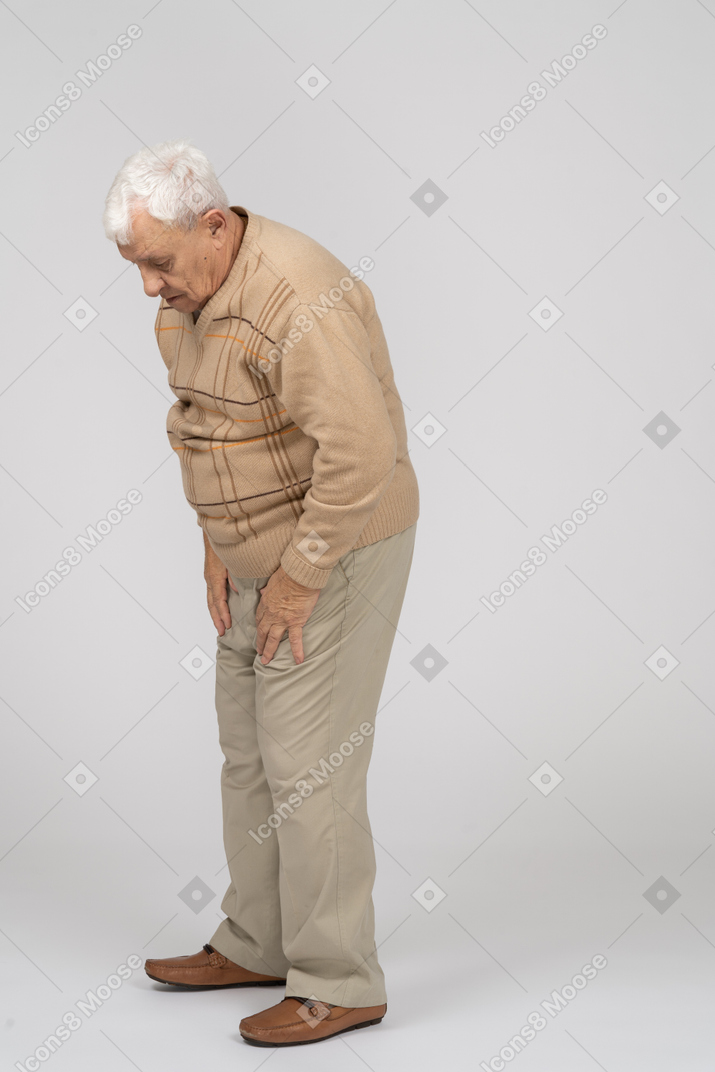 Вид сбоку грустного старика в повседневной одежде, смотрящего вниз