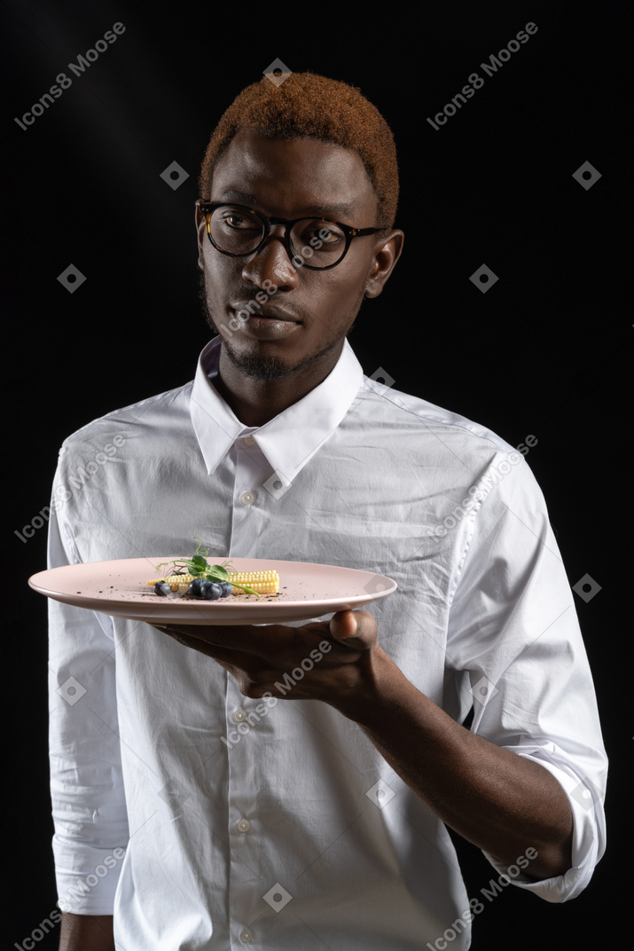 A waiter is serving the dish