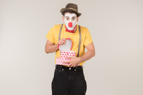 Sad male clown holding empty gift box