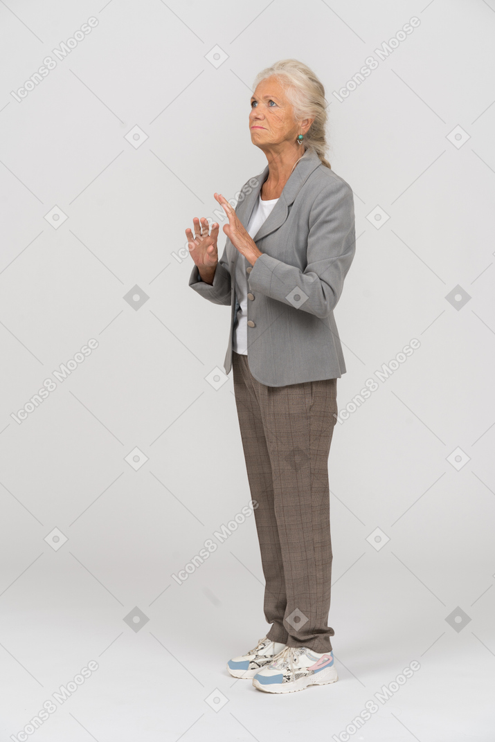 Vue latérale d'une vieille dame en costume montrant un panneau d'arrêt