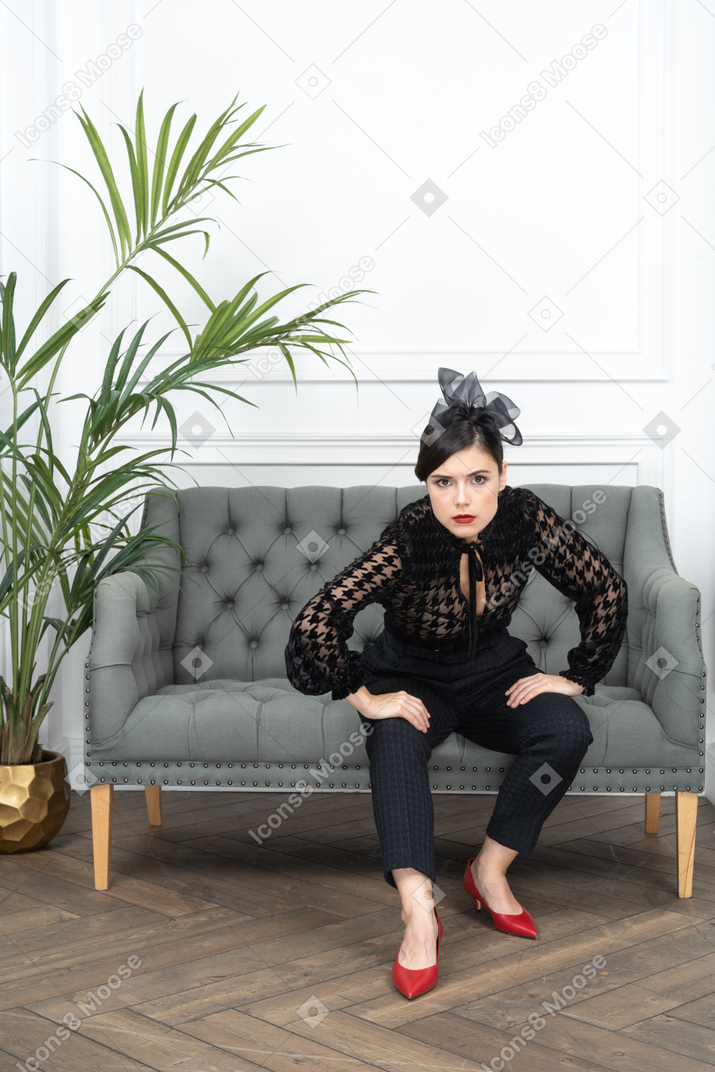 Woman sitting on couch in threatening pose