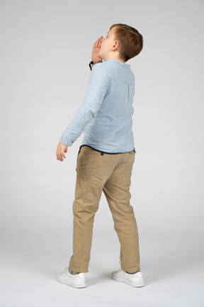 Back view of a boy calling someone