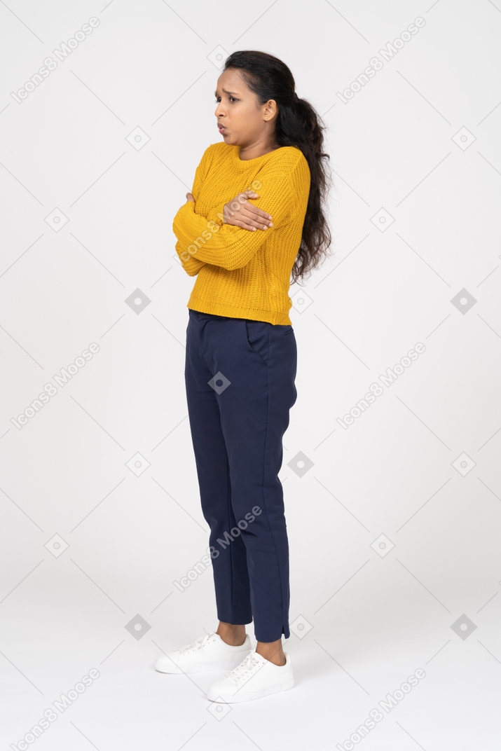 一个穿着休闲服的女孩双臂交叉站立的侧视图