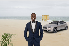 A man in a tuxedo standing in front of a car