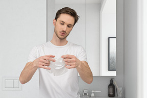 Man putting on sheet mask