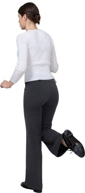 一个穿着办公室服装的年轻女子抬起腿的侧视图