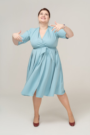 一个穿着蓝色连衣裙跳舞的快乐女人的前视图