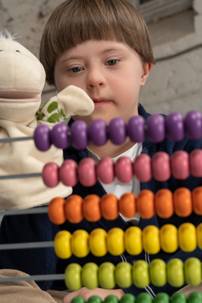 Little boy looking attentively at colorful beads
