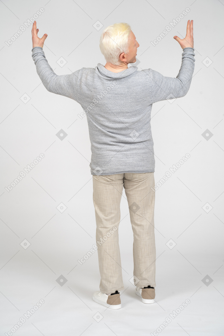 Vista posteriore di un uomo in piedi con le braccia alzate