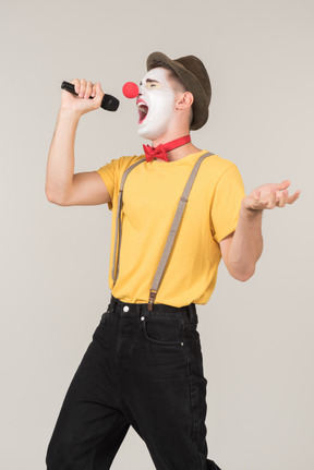 Male clown singing into a microphone