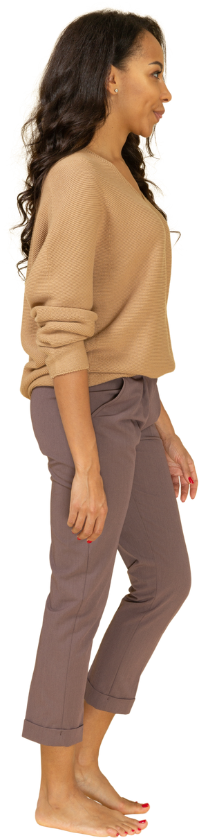 Vista lateral de una mujer joven en ropa casual haciendo una mueca