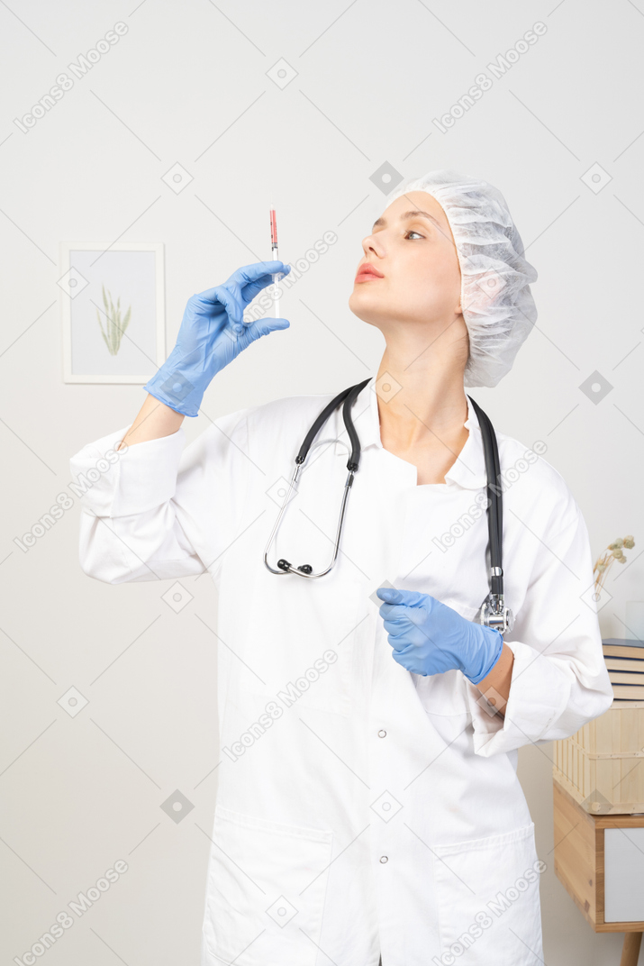 Vista frontal de una joven doctora sosteniendo una jeringa