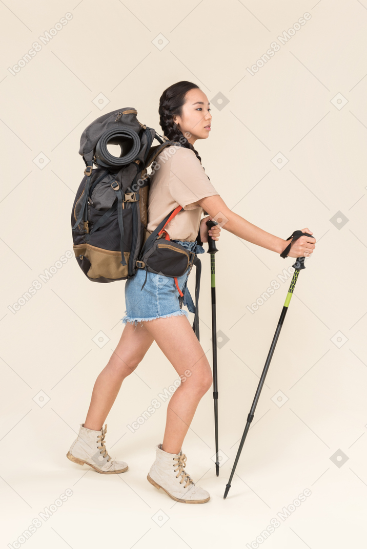 トレッキングポールを使用して歩くハイカー女性
