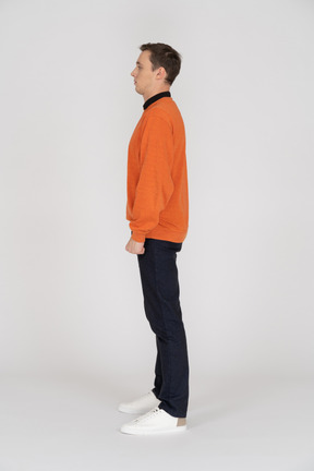 Joven en sudadera naranja de pie