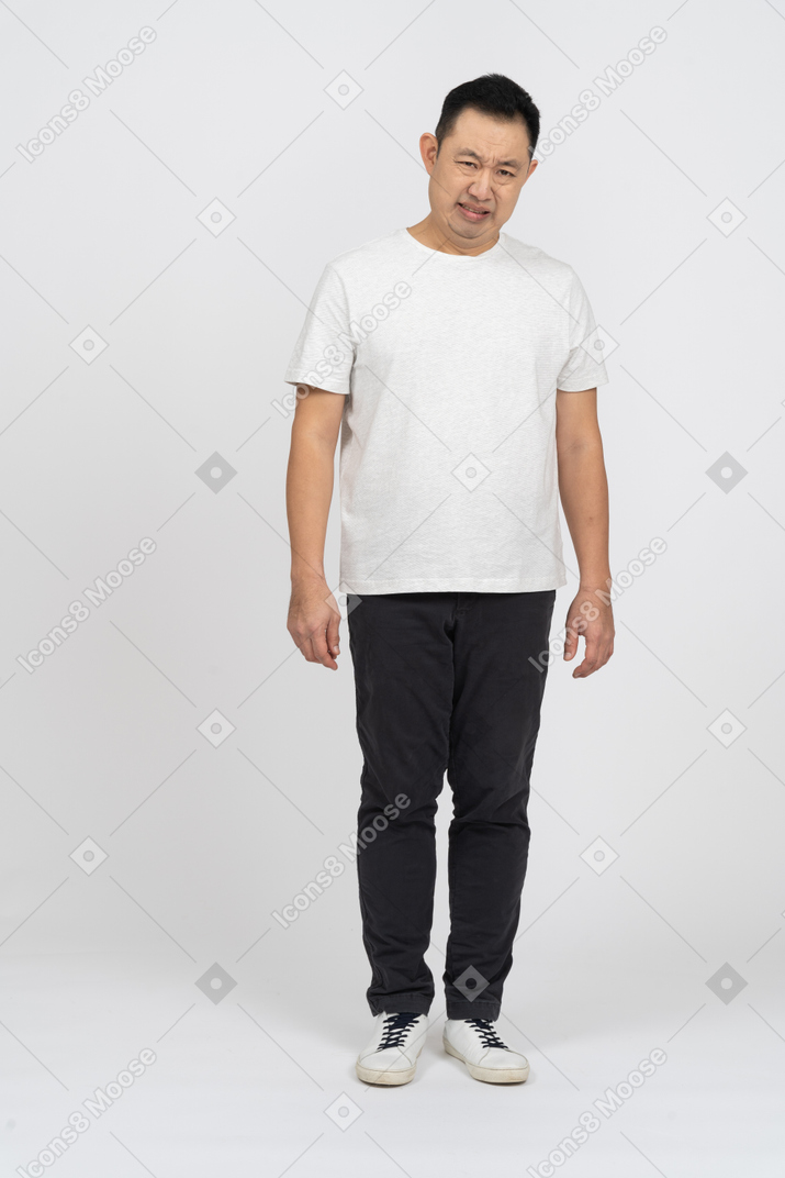 Front view of a man in casual clothes looking at something disgusting