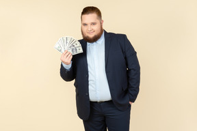 A plus-size man in a black costume with dollar bills in his hands