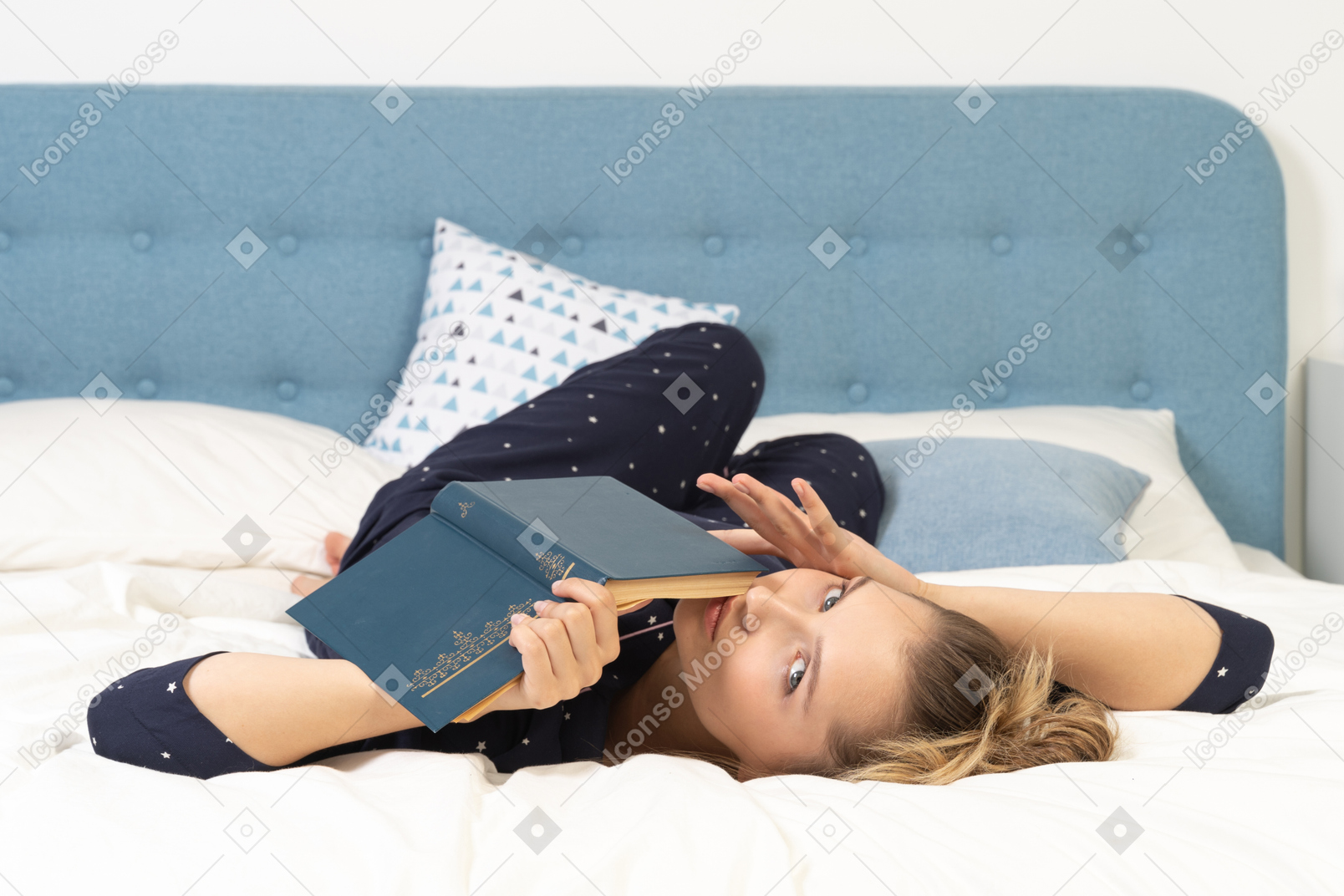 Full-length of a young female reading book in bed