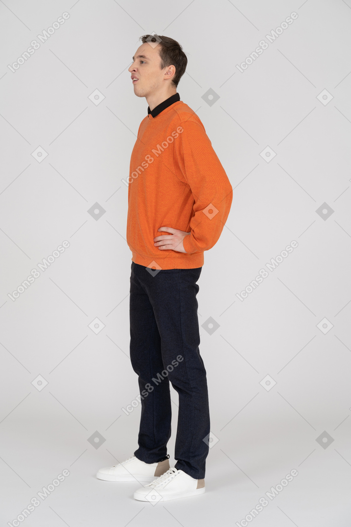 Junger mann im orangefarbenen sweatshirt stehend
