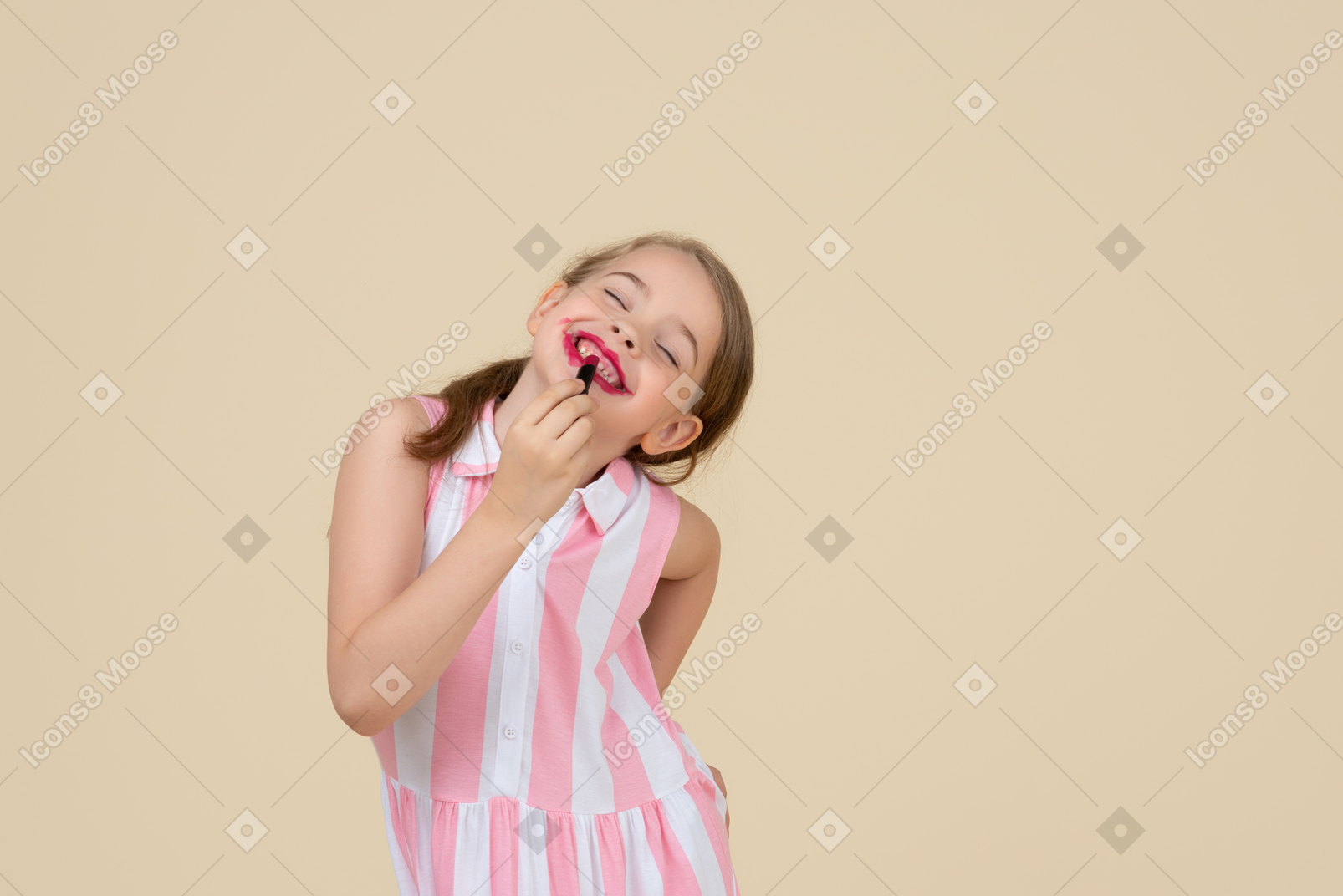 Cute little girl applying red lipstick