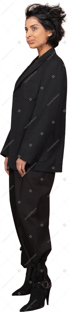 Vista de três quartos de uma mulher de negócios descontente com uma careta em um terno preto olhando para o lado