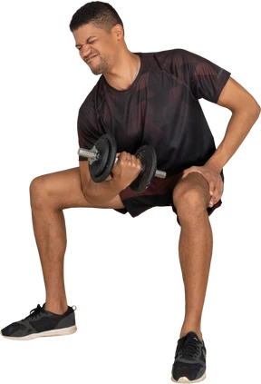 Young man in sports clothes lifting weigths