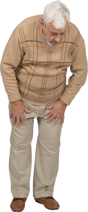 Vista frontal de un anciano con ropa informal mirando hacia abajo