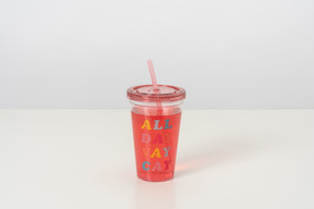 A cute plastic cup with a lid and a straw, full of pink-coloured cocktail, looking cool and aesthetically pleasing