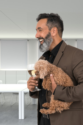 A man holding a dog and a wine glass
