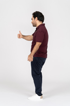 Side view of man showing thumb up