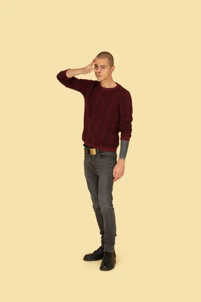 Three-quarter view of a funny young man touching his nose