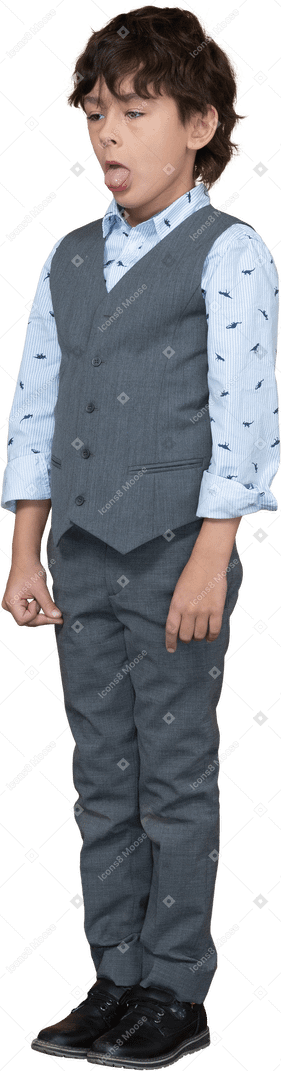 舌を示す灰色のスーツを着たかわいい男の子の正面図