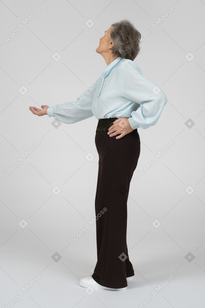 Side view of an old woman stretching out her hand