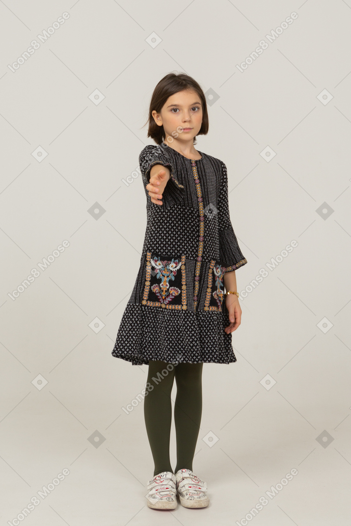 Front view of a little girl in dress outstretching her hand