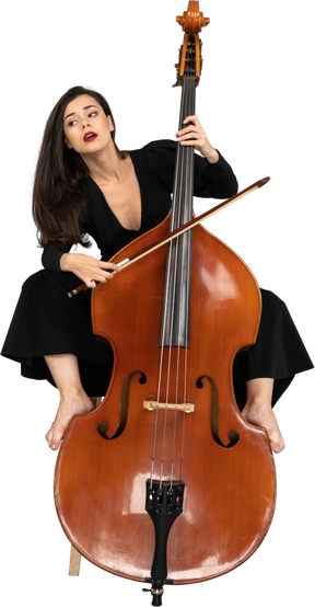 Front view of a young lady sitting on a chair while putting legs on double-bass