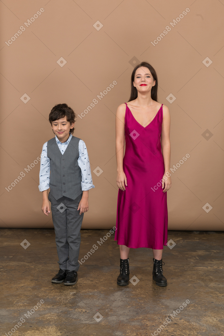 Front view of a boy and woman standing still