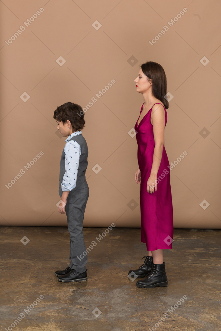 Niño y mujer joven de pie en el perfil