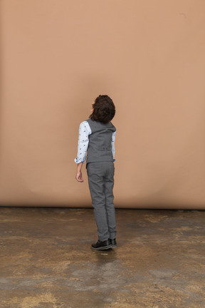 Rear view of a boy in suit looking up