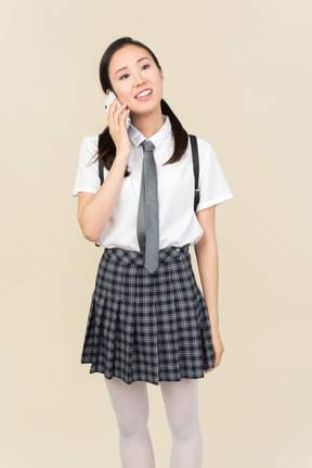 Asian school girl involved in phone conversation