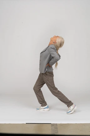 Side view of an old lady in suit doing yoga