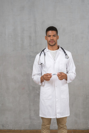 Male doctor holding a thermometer