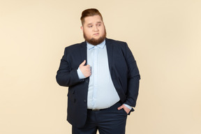 Young overweight man in suit touching jacket with a hand