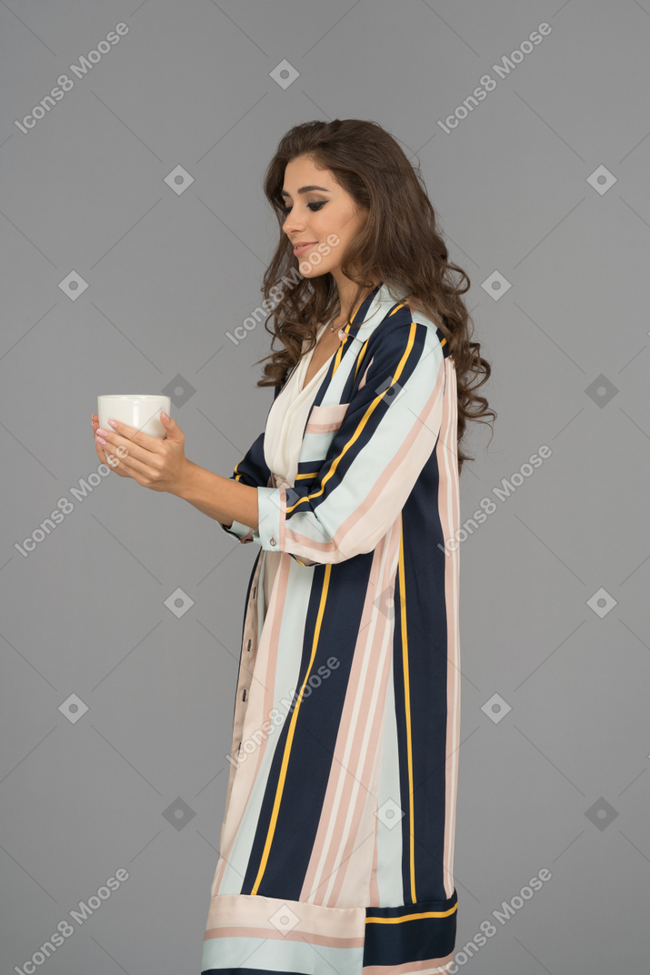 Cute middle eastern female holding a big white cup with both hands