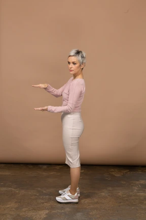 Side view of a woman in casual clothes showing the size of something