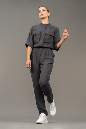 Front view of a walking young woman in a jumpsuit