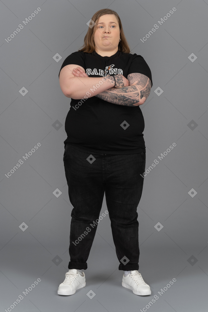 Plump woman looking thoughtfully with her arms crossed