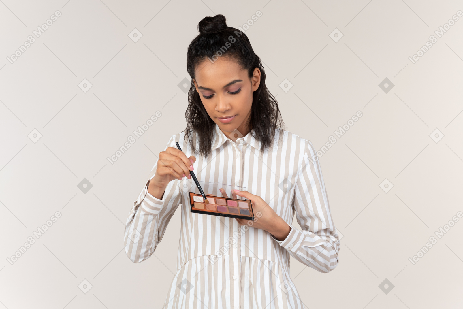 Young woman putting on eyeshadows