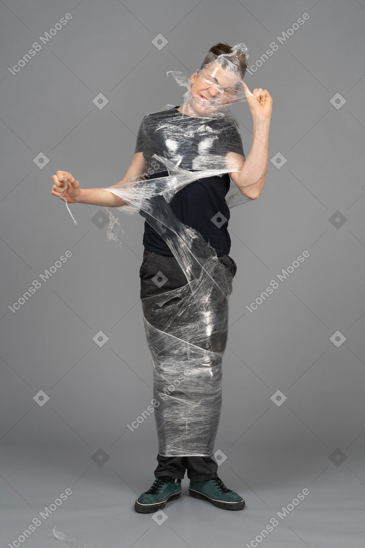 Young man wrapping plastic around him